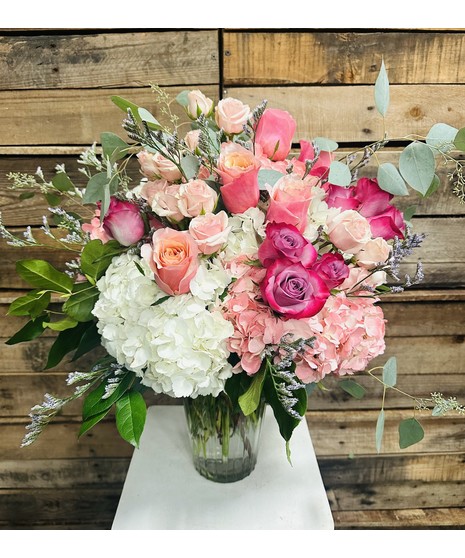 Pretty Pastel - Elegant greenry embraces pastel roses and hydranges in a clear glass vase,