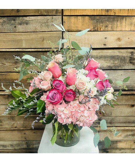 Pretty Pastel - Elegant greenry embraces pastel roses and hydranges in a clear glass vase,