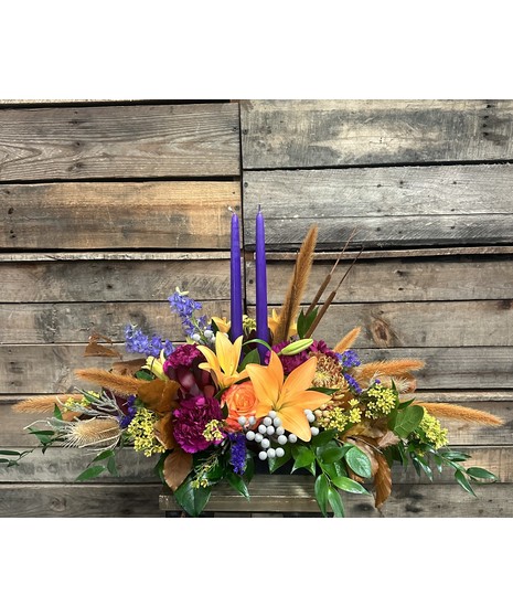 fall toned floral centerpiece with tall purple candles